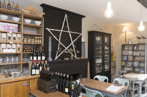 Bar à vin moderne au Les Filles du Bord de Mer à Port-en-Bessin avec étagères en bois, bouteilles de vin et décoration étoilée
