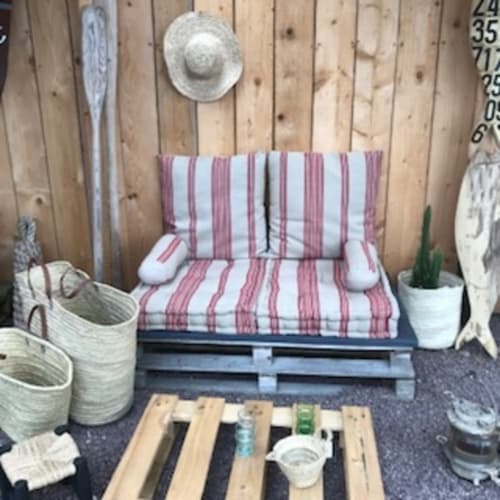 Coin salon cosy avec coussins rayés rouges aux Filles du Bord de Mer, Port-en-Bessin-Huppain