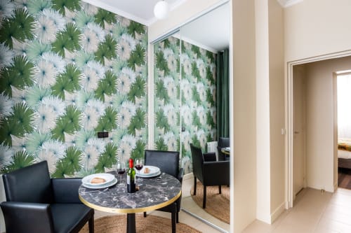 Studio apartment dining area at Hotel Residence Europe & Spa with botanical wallpaper, round table, and mirrored wall in