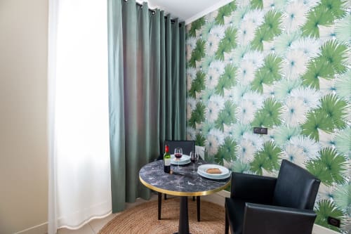 Studio apartment at Hotel Residence Europe & Spa in Clichy with dining table, black chairs, marble top, tropical wallpaper,