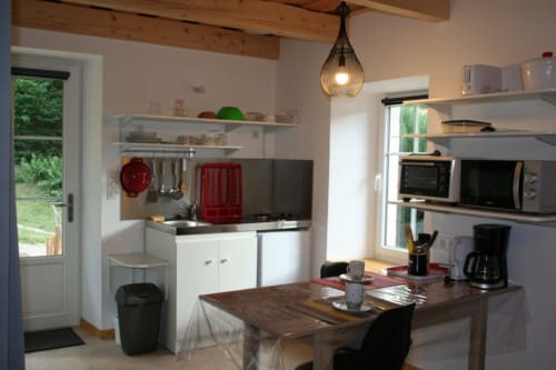 La cuisine équipée du gite "Azuré" avec terrasse  et vue sur la foret.