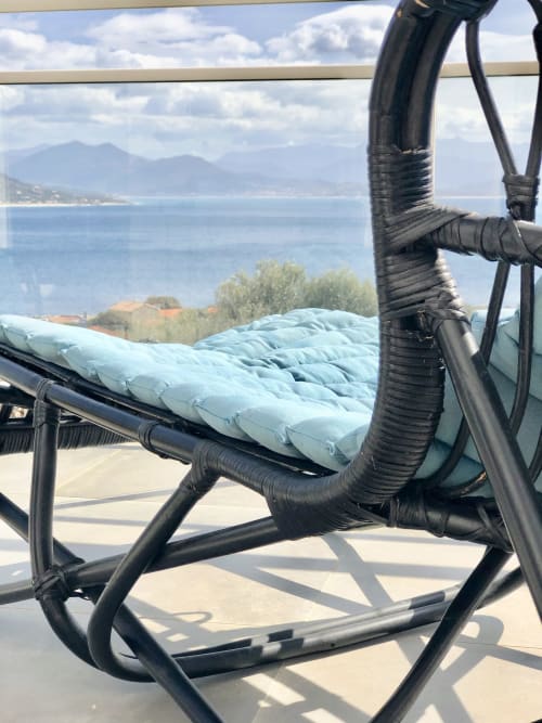 Black hammock with light blue cushion overlooking Mediterranean sea and mountains at Villas Marincelu, Corsica