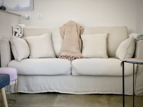 Cream-colored sofa with cushions and throws in Casa Serena villa at Villas Marincelu, Corsica
