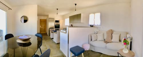Modern open-plan living area at Villas Marincelu in Porto Pollo with kitchen, dining table, and cream sofa