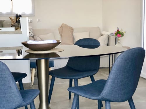 Modern dining area at Villas Marincelu with blue chairs, glass table, cream sofa, and fresh flowers in Porto Pollo villa