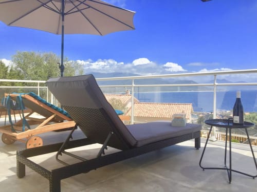 Beachfront terrace at Villas Marincelu with lounge chair, umbrella, sea views, and wine service on Corsica