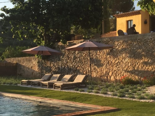 Saint Martin B&B in Ollioules: Poolside terrace with loungers, umbrellas, stone walls and yellow cottage