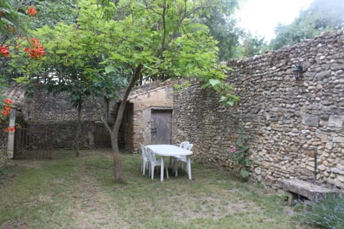White table and chairs in stone courtyard garden at Domaine de Lamartine cottage, Pont-Saint-Esprit