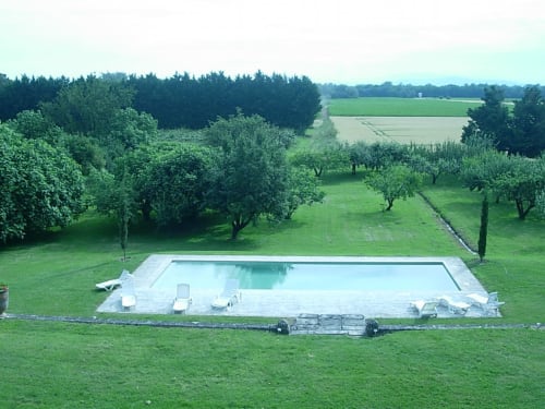 Rectangular swimming pool in manicured garden with fruit trees and countryside views at Domaine de Lamartine,