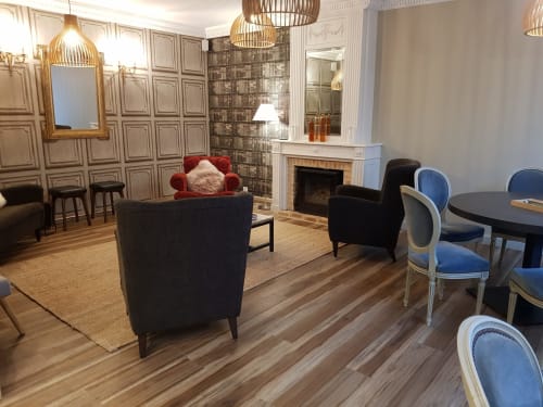 Élégant salon de l'hôtel Les Cabines à Houlgate avec cheminée, luminaires dorés et mobilier contemporain