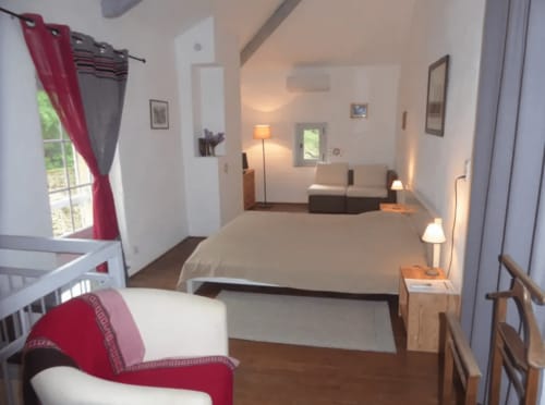 Chambre spacieuse au gîte Domaine de Lamartine à Pont-Saint-Esprit avec lit queen-size, éclairage moderne et coin salon confortable