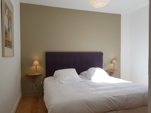 Chambre moderne de l'hôtel Les Cabines à Houlgate avec tête de lit noire, literie blanche et lampes de chevet