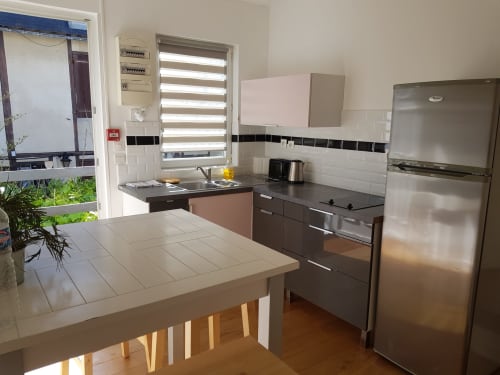 Cuisine moderne de l'appartement Les Cabines à Houlgate, avec appareils en acier inoxydable et coin repas