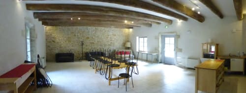 Spacious dining area in La Bergerie cottage at Domaine de Lamartine with wooden beams, stone walls, and multiple seating