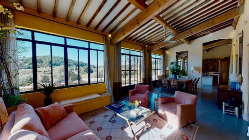 Bright living room at Saint Martin B&B in Ollioules with pink furniture, exposed beams, large windows overlooking countryside