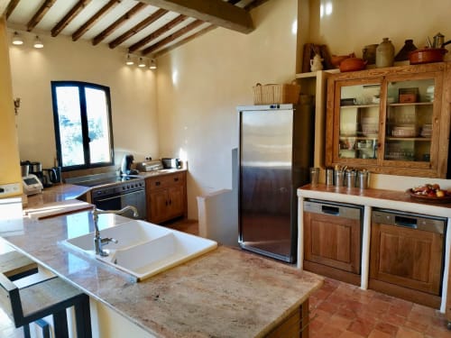 Cuisine du gîte Saint Martin à Ollioules avec poutres en bois, électroménagers inox et plan de travail en marbre