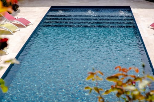 Piscine du gîte Le Pignié à Lescure-d'Albigeois avec chaises longues et fleurs