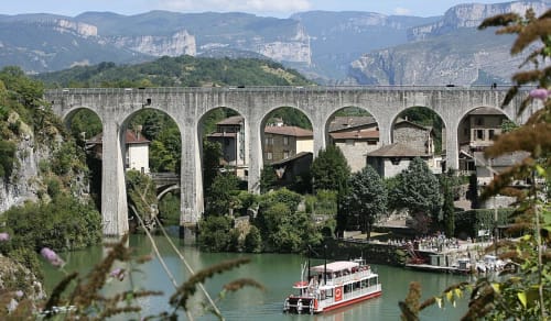 L'aqueduc de Pont-en-Pierres enjambe la rivière turquoise près de Chanos-Curson avec falaises calcaires et petit bateau rouge