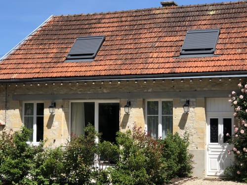 Charming stone cottage annex at Le château d'Hermonville in Hermonville with terracotta roof, white doors, and flowering