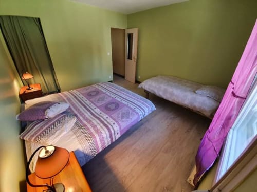 La chambre principale de l'appartement des Vieux Prés a été améliorée d'un lit bébé et d'un portant pour vêtement depuis cette photo