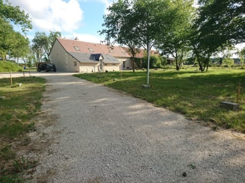 Allée de graviers menant au gîte Les gîtes des châteaux à Vallières-les-Grandes, France, entouré de pelouses verdoyantes