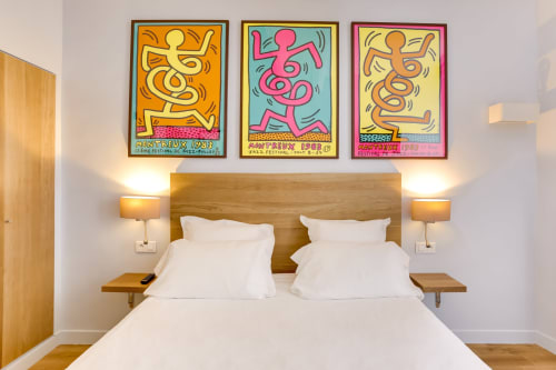 Chambre d'hôtel moderne à l'Hôtel Louvre Richelieu Paris avec affiches de pop art colorées au-dessus du lit en bois