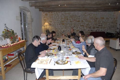 Group dining event at Domaine de Lamartine in Pont-Saint-Esprit, guests enjoying meal in rustic stone cottage