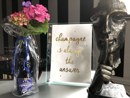 Pink geraniums, champagne quote sign, and sculptural head at Le château d'Hermonville luxury B&B in Hermonville, France