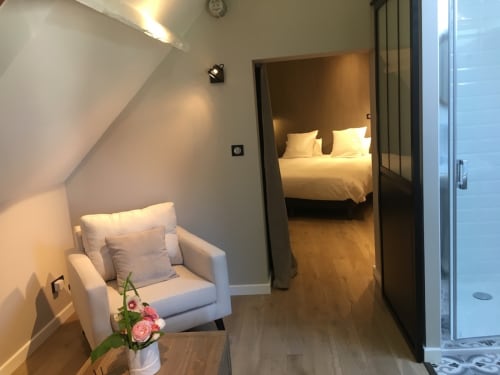Modern bedroom suite at Le château d'Hermonville with armchair, flowers, and ensuite in Hermonville, France