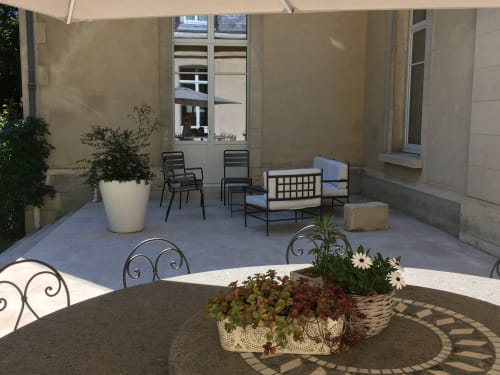 Outdoor patio at Le château d'Hermonville with flowering plants, seating, and stone courtyard in Hermonville, France