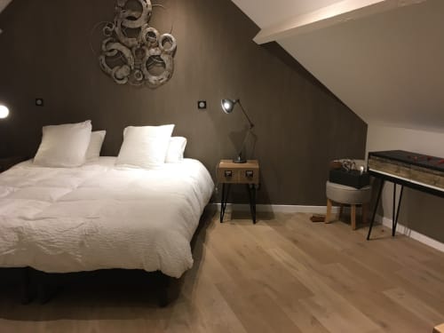 Modern attic bedroom at Le château d'Hermonville with white bedding, wooden nightstand, and dark accent wall in Hermonville,