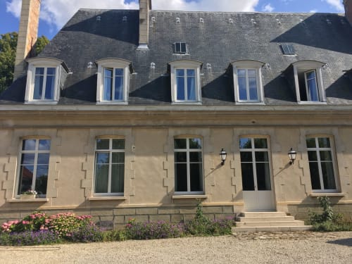 Le château d'Hermonville BnB facade with mansard roof, dormer windows, and flowering gardens in Hermonville, France
