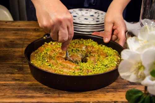 Serveur présentant une paella traditionnelle aux Filles du Bord de Mer, Port-en-Bessin