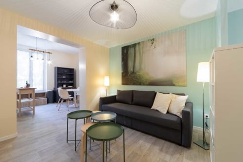 Appartement Valériane à Un Air De Famille, Vittel - salon moderne avec canapé noir, murs verts et espace de travail