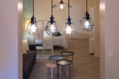 Luminaires suspendus géométriques modernes dans l'appartement Valériane d'Un Air De Famille à Vittel, au-dessus de la zone repas