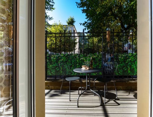 Balcon privé à Un Air De Famille à Vittel avec coin de repos, balustrade couverte de lierre et vue sur le jardin