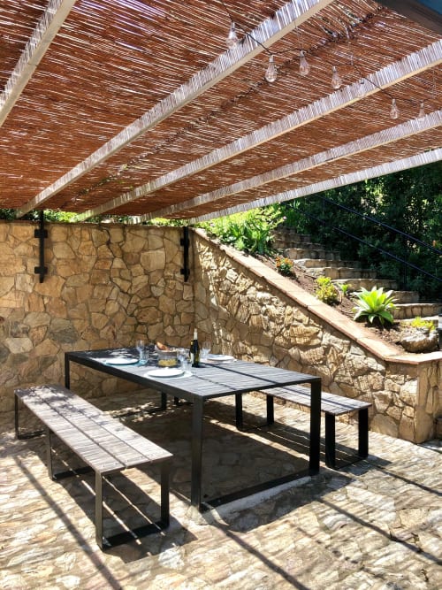 Speisebereich im Freien in Ty Pals mit Steinmauern, geflochtener Pergola und gedecktem Tisch in Pals, Spanien