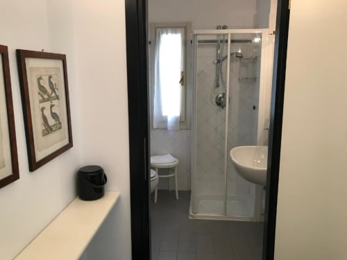 Modernes Badezimmer im Hotel Beau Rivage in Alassio mit Dusche, Waschbecken, Toilette und Wandkunst