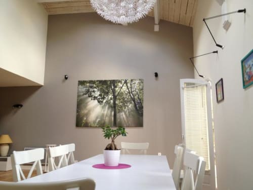 La salle à manger, avec sa belle hauteur sous plafond, est sublimée par un grand lustre au design original, apportant charme et élégance à vos repas