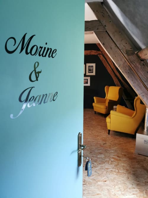 Chambre Morine & Jeanne à La Cour d'Hortense : murs turquoise, fauteuils jaunes et plafond mansardé aux poutres apparentes
