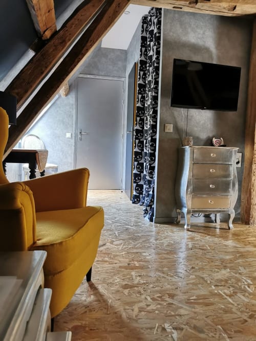 Coin salon confortable avec fauteuil jaune et mobilier contemporain à La Cour d'Hortense, gîte à Sailly-Flibeaucourt