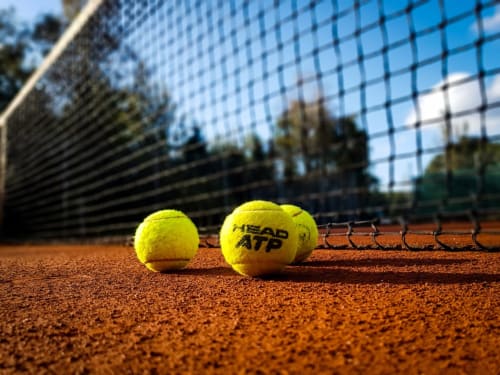 Deux balles de tennis ATP sur un court de terre battue avec filet à l'hôtel Les Cabines à Houlgate