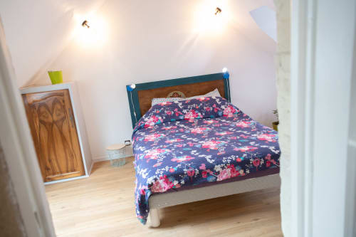 Chambre douillette aux Gîtes des Châteaux à Vallières-les-Grandes, avec literie fleurie et boiseries