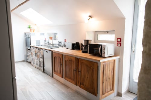 Cuisine chaleureuse du gîte Les châteaux avec mobilier en bois, électroménagers inox et comptoir repas