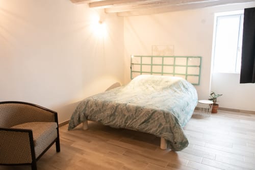 Chambre spacieuse aux Gîtes des Châteaux à Vallières-les-Grandes avec lit, tête de lit verte, parquets en bois et