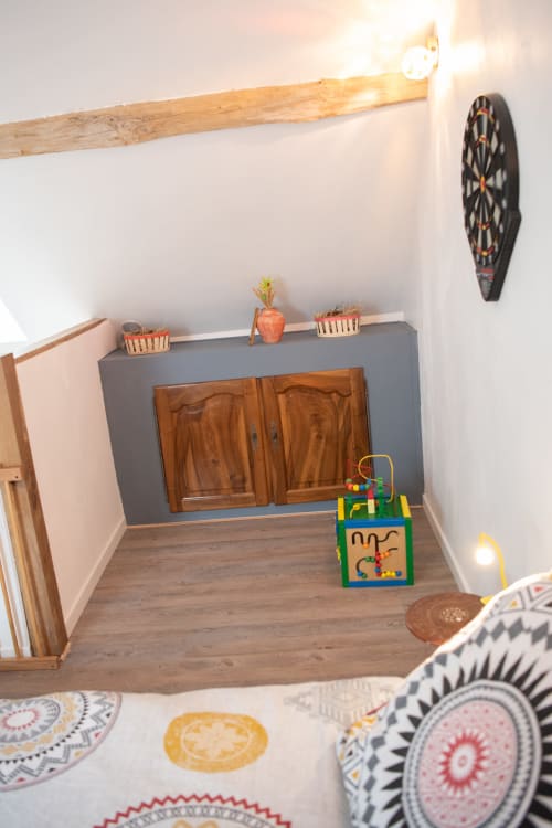 Salle de jeux douillette aux gîtes des châteaux avec mobilier en bois, jeu de fléchettes et jouets colorés pour enfants