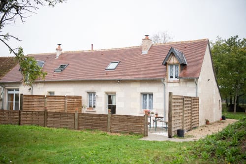 Gîte des châteaux à Vallières-les-Grandes : cottage avec clôture en bois, murs blancs et toit en terre cuite