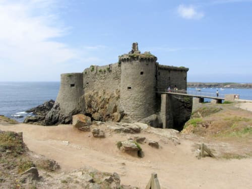Historic stone fortress on sandy beach near Les Sables-d'Olonne with sea and visitors