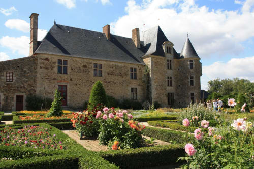 Historic stone château with pink roses in formal gardens at Hôtel Maison Richet, Les Sables-d'Olonne