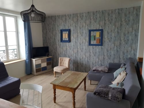 Spacieux séjour du gîte Vue D'ici à Saint Valery sur Somme avec mobilier moderne et papiers peints texturés